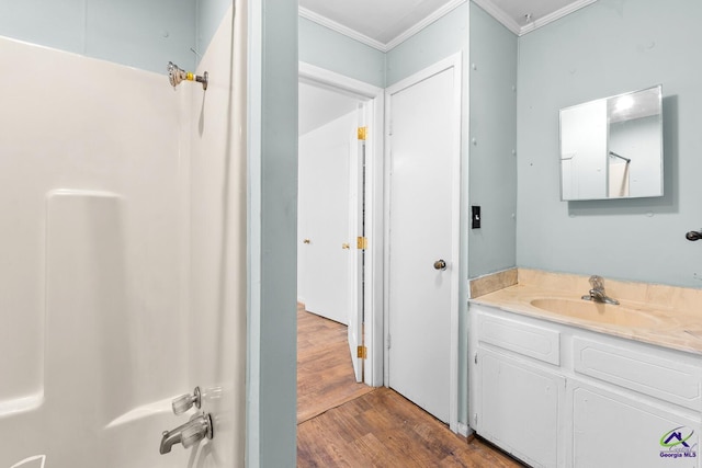 bathroom featuring vanity, hardwood / wood-style floors, crown molding, and shower / bathtub combination