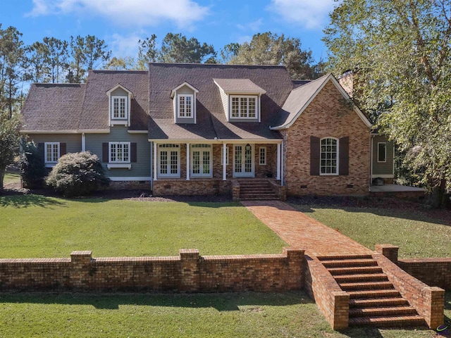 cape cod home with a front yard and french doors