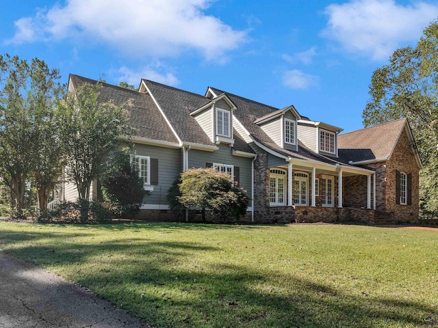 new england style home with a front yard and covered porch