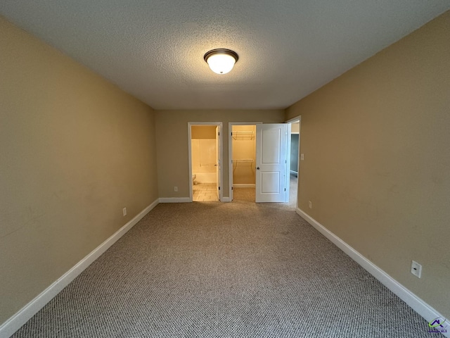 spare room with a textured ceiling and carpet flooring