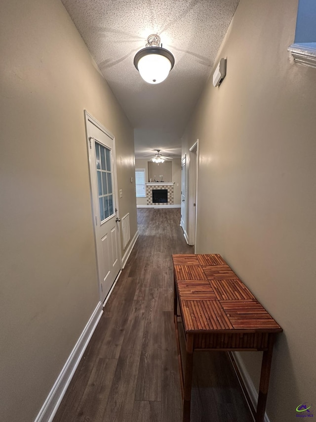 hallway featuring dark hardwood / wood-style floors and a textured ceiling