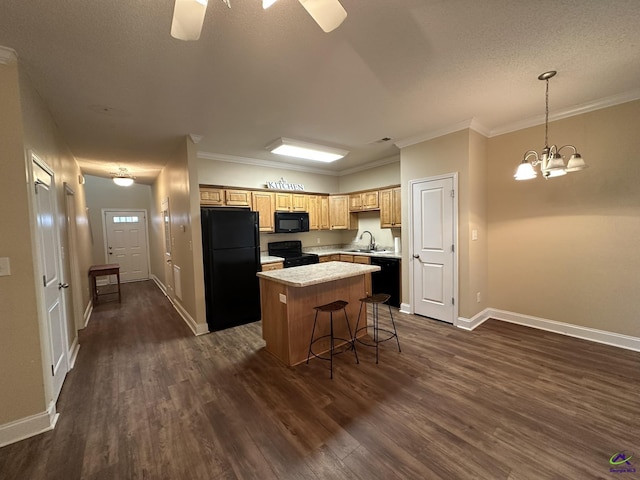 kitchen with a breakfast bar area, hanging light fixtures, a center island, black appliances, and dark hardwood / wood-style flooring