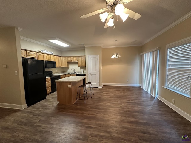 kitchen featuring sink, a breakfast bar area, a center island, hanging light fixtures, and black appliances