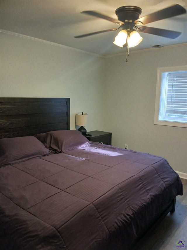 bedroom with wood-type flooring, ornamental molding, and ceiling fan