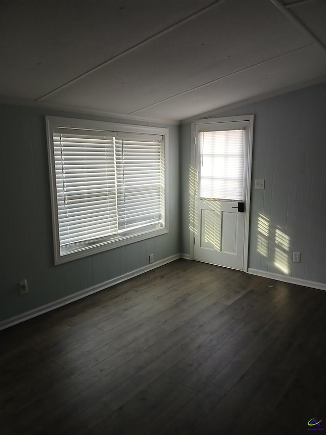 unfurnished room featuring dark wood-type flooring and vaulted ceiling