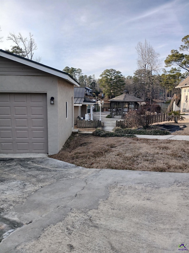 exterior space with a garage and a gazebo