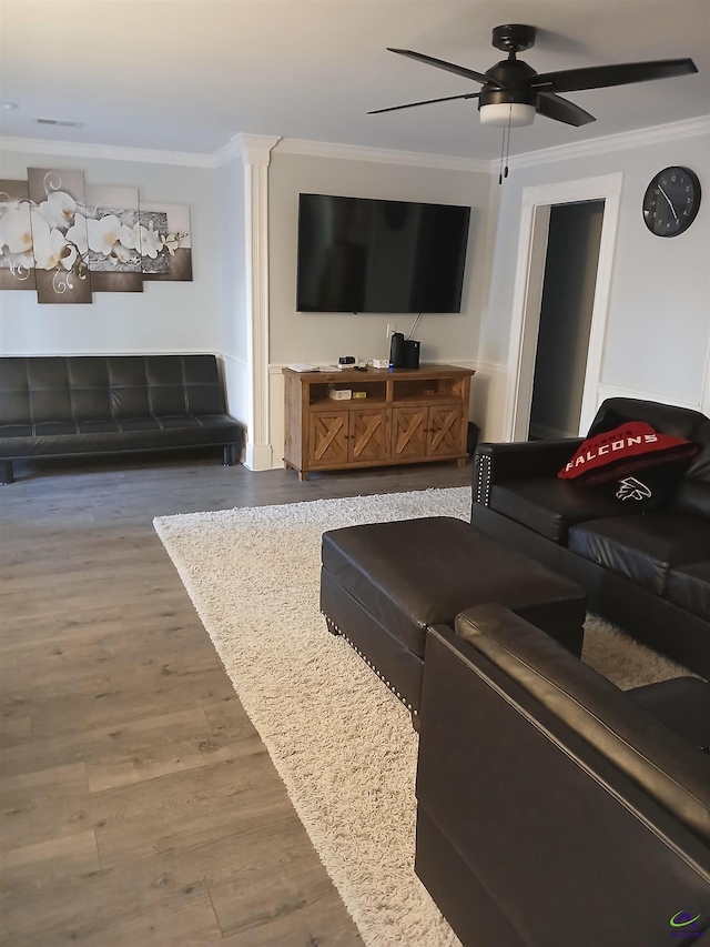 living room with hardwood / wood-style flooring, ceiling fan, and ornamental molding