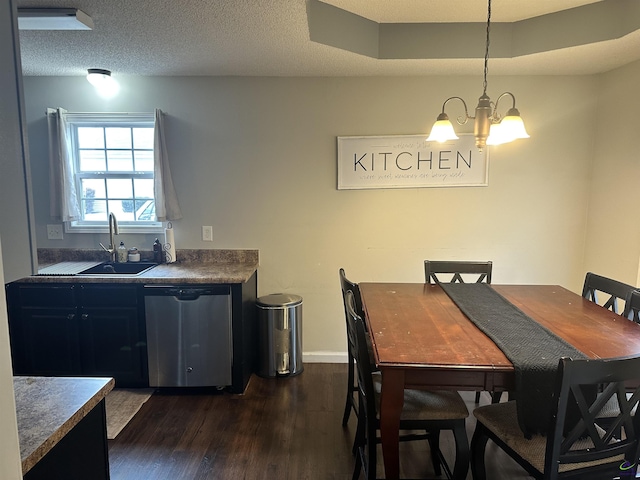 dining area featuring sink, a chandelier, a textured ceiling, and dark hardwood / wood-style flooring