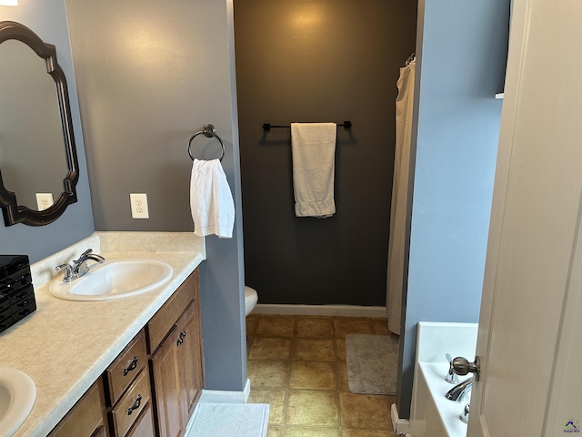 bathroom featuring vanity, a bath, and toilet