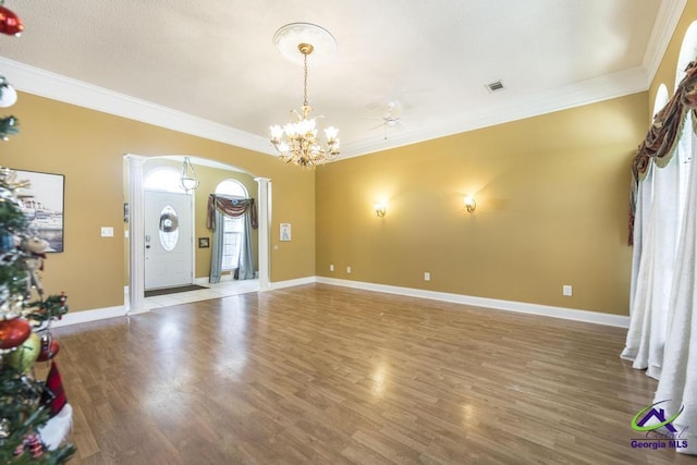 unfurnished living room featuring crown molding, hardwood / wood-style floors, and an inviting chandelier