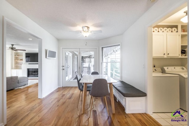 dining area featuring ceiling fan, washer and clothes dryer, light hardwood / wood-style floors, and a textured ceiling