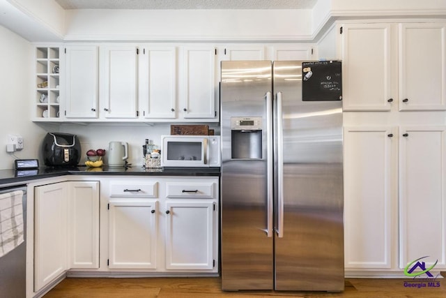 kitchen featuring stainless steel fridge with ice dispenser and white cabinets