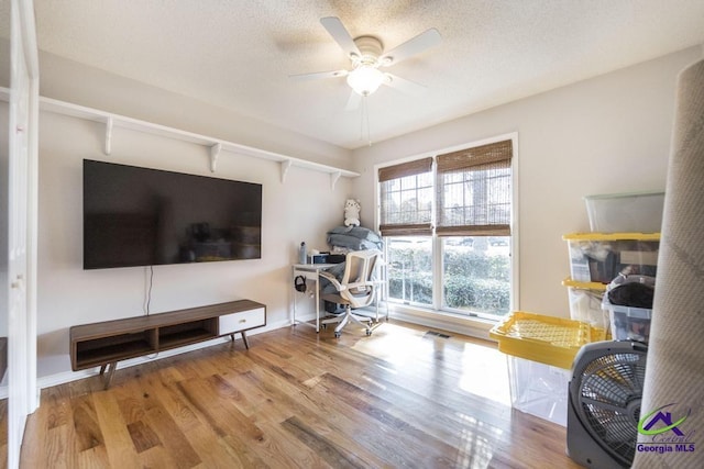 office with hardwood / wood-style flooring, a textured ceiling, and ceiling fan