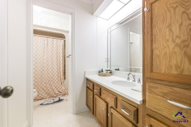 bathroom with vanity, tile patterned floors, toilet, and walk in shower