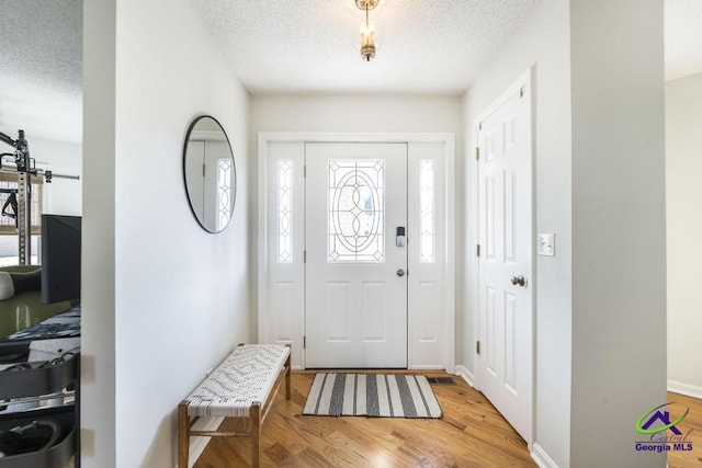 entryway with hardwood / wood-style flooring and a textured ceiling