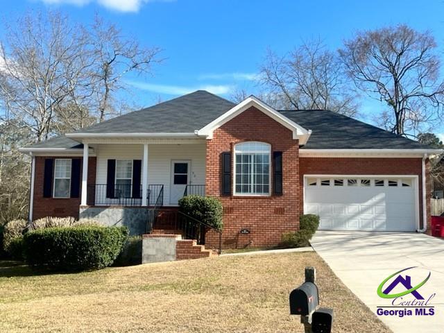 view of front of house with a porch, a garage, and a front yard