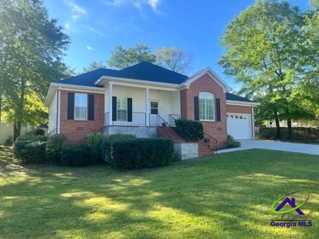 single story home with a porch, a garage, and a front yard