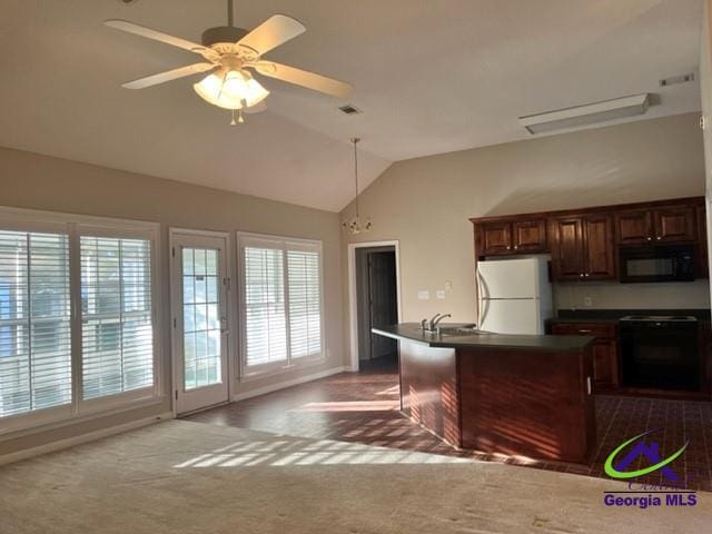 kitchen with lofted ceiling, ceiling fan, range, white refrigerator, and dark carpet