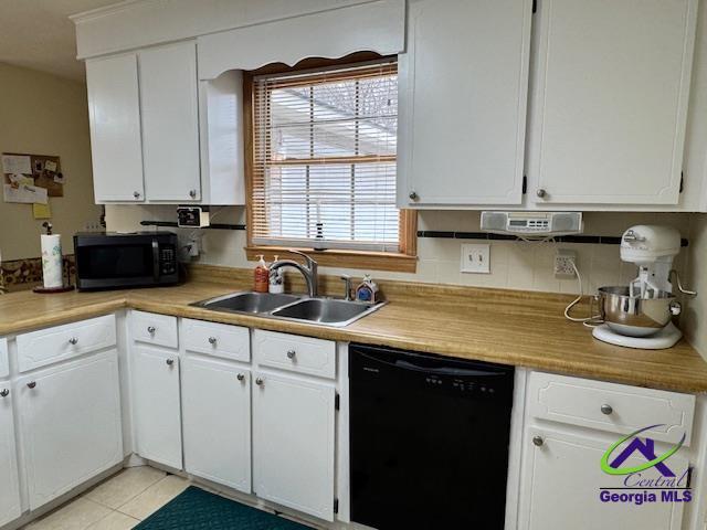 kitchen with white cabinets, light tile patterned floors, sink, and black appliances