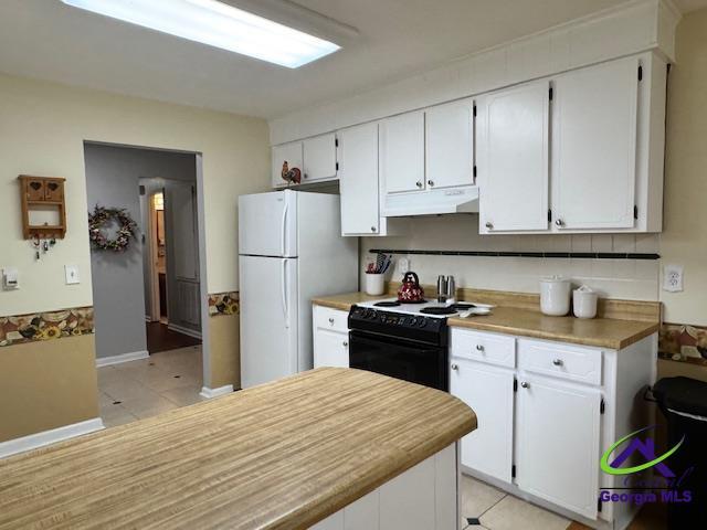 kitchen featuring white cabinetry, black range with electric stovetop, light tile patterned flooring, and white fridge