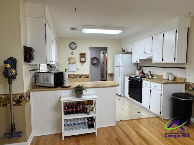 kitchen with white cabinetry, light hardwood / wood-style floors, and black / electric stove