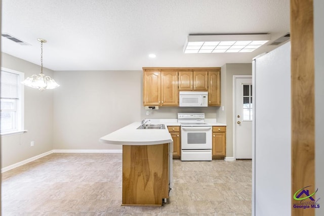 kitchen featuring sink, a chandelier, hanging light fixtures, kitchen peninsula, and white appliances