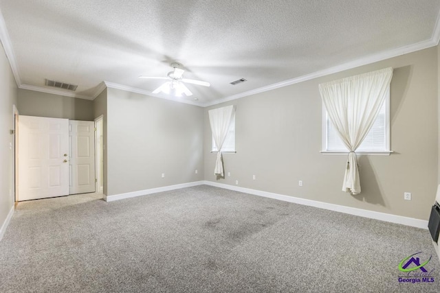 carpeted spare room with ceiling fan, crown molding, and a textured ceiling