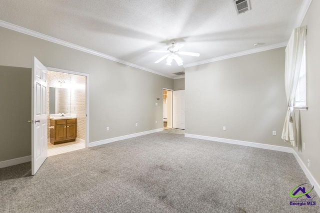 unfurnished bedroom featuring sink, crown molding, connected bathroom, a textured ceiling, and light colored carpet