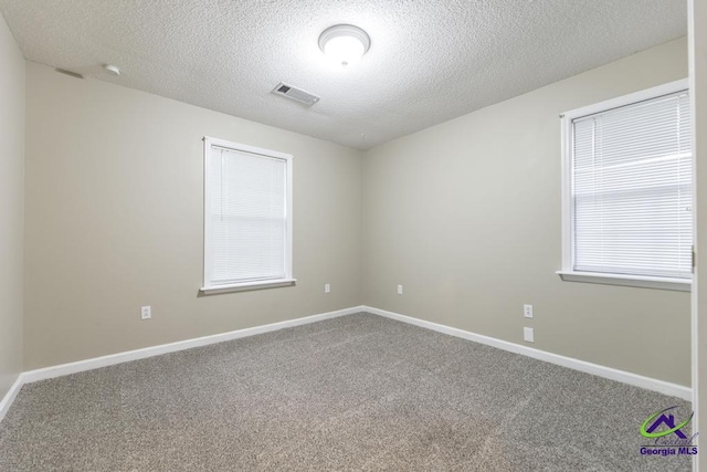 carpeted spare room featuring a textured ceiling