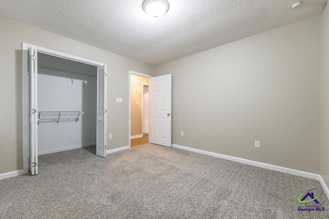 unfurnished bedroom featuring carpet flooring, a closet, and a textured ceiling