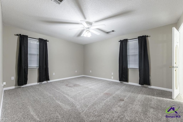 unfurnished room with a textured ceiling, ceiling fan, and carpet flooring