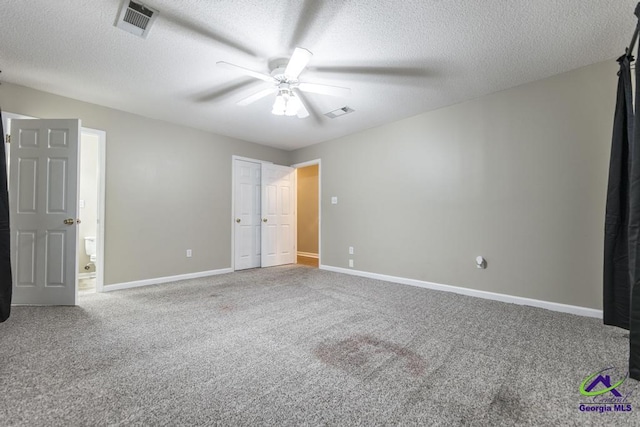 unfurnished bedroom with ceiling fan, carpet floors, and a textured ceiling