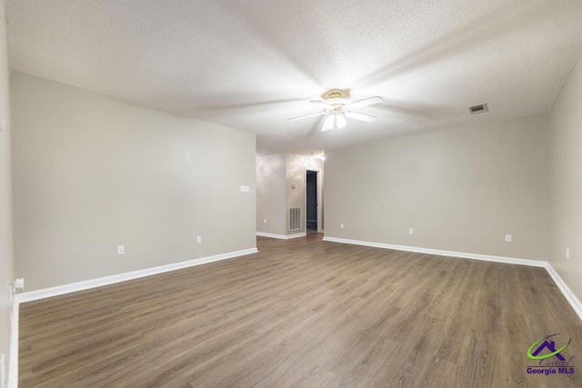 empty room featuring hardwood / wood-style flooring, a textured ceiling, and ceiling fan