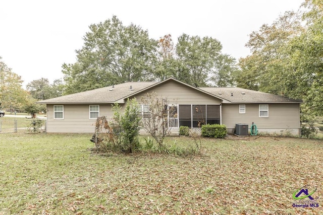 back of property featuring central AC, a sunroom, and a lawn