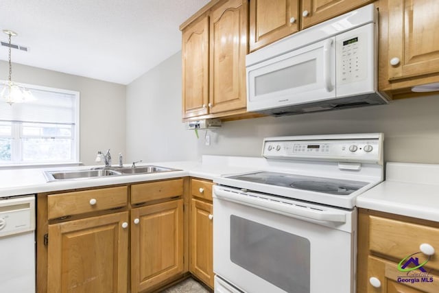 kitchen with sink, white appliances, and decorative light fixtures