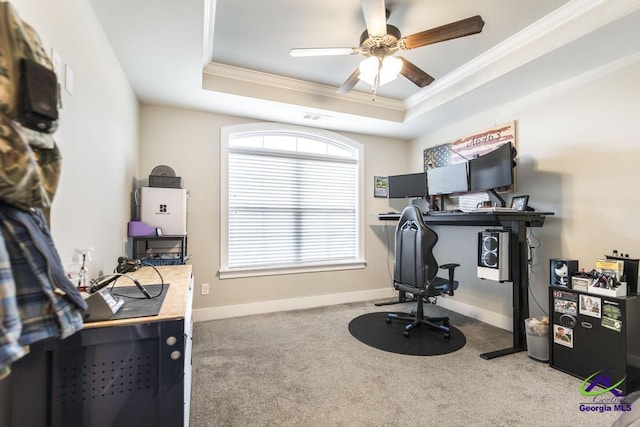 office area featuring ornamental molding, a raised ceiling, ceiling fan, and carpet