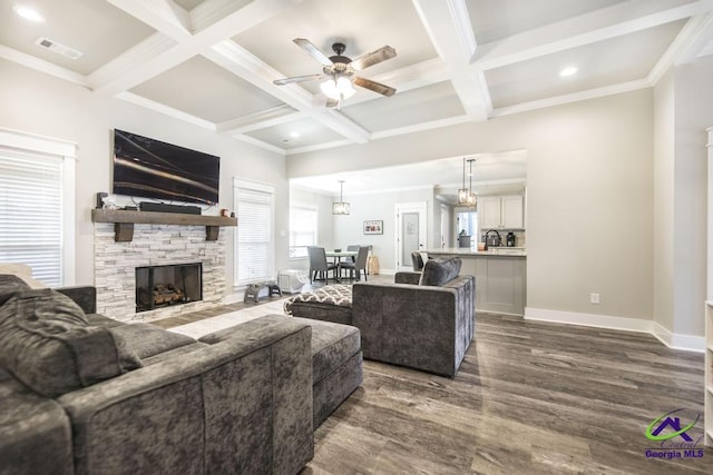 living room with ceiling fan, beam ceiling, dark hardwood / wood-style floors, coffered ceiling, and a fireplace