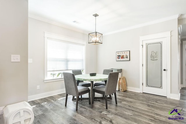 dining room with crown molding, dark hardwood / wood-style flooring, and a notable chandelier