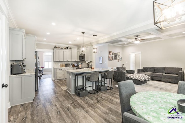 dining space with coffered ceiling, crown molding, dark hardwood / wood-style floors, and beamed ceiling