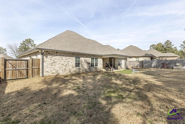 back of property with a yard and a patio area