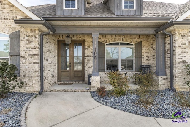 view of exterior entry featuring french doors and a porch