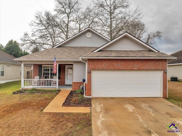 view of front facade featuring cooling unit, a garage, and covered porch