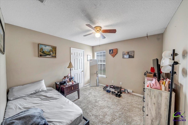 carpeted bedroom with ceiling fan and a textured ceiling