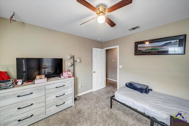 carpeted bedroom featuring ceiling fan and a textured ceiling