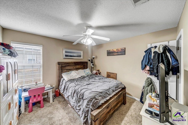 bedroom featuring ceiling fan, light colored carpet, and a textured ceiling