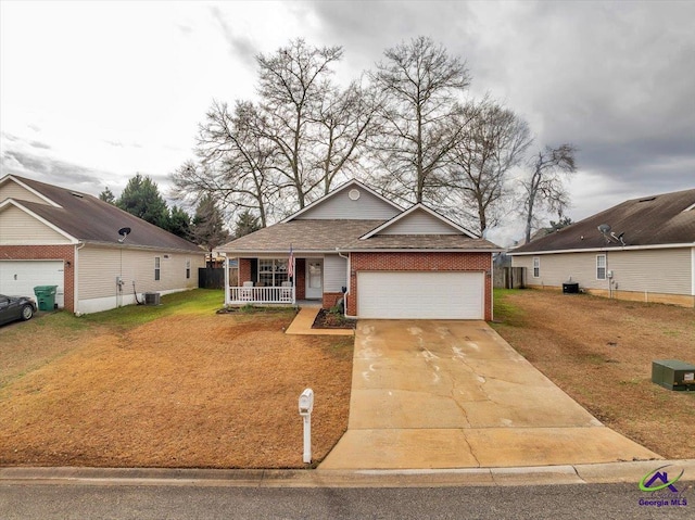 view of front of house with a garage, a front yard, central AC, and covered porch