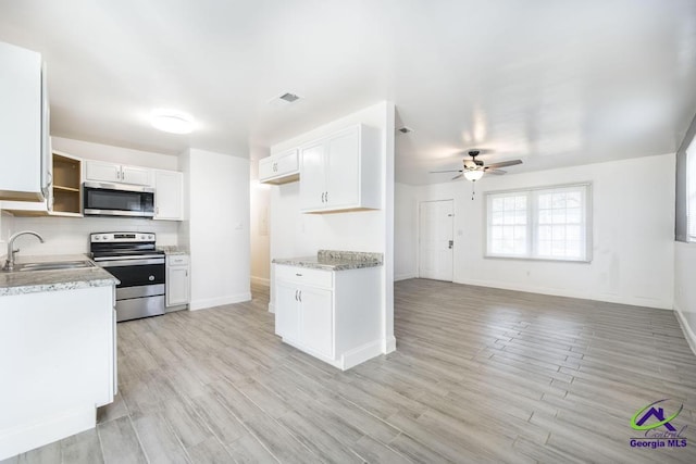 kitchen with white cabinetry, appliances with stainless steel finishes, sink, and backsplash