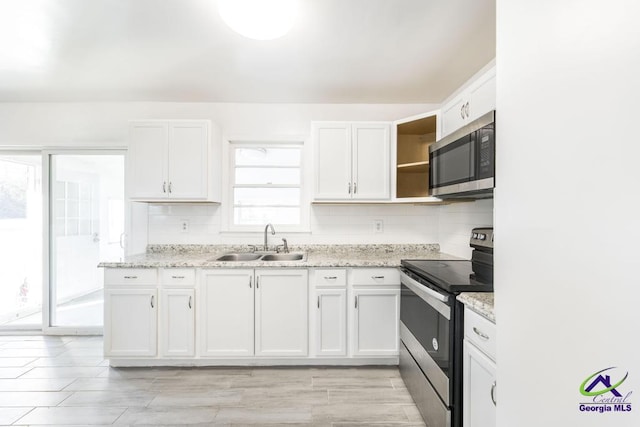 kitchen with stainless steel appliances, sink, and white cabinets