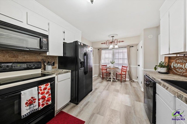 kitchen with decorative backsplash, black appliances, light hardwood / wood-style floors, and white cabinets