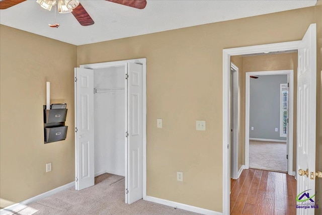 carpeted bedroom featuring ceiling fan and a closet